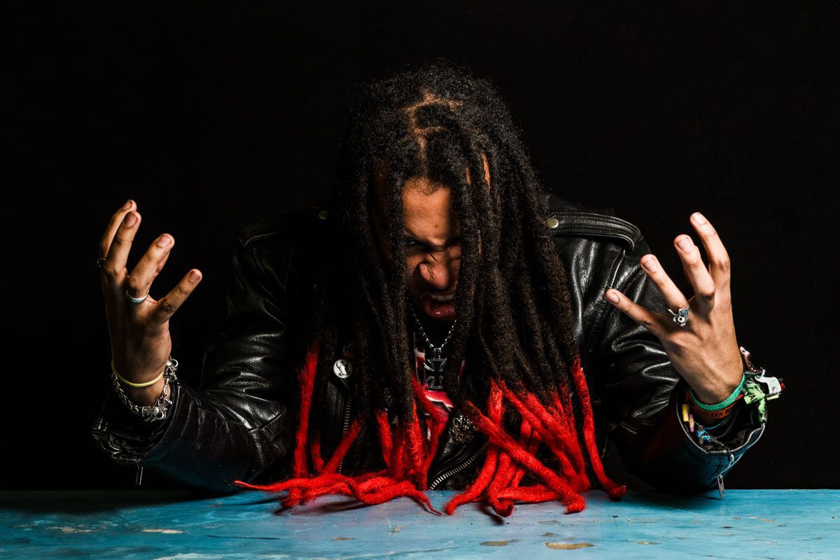 A metalhead with long hair sitting at a table.