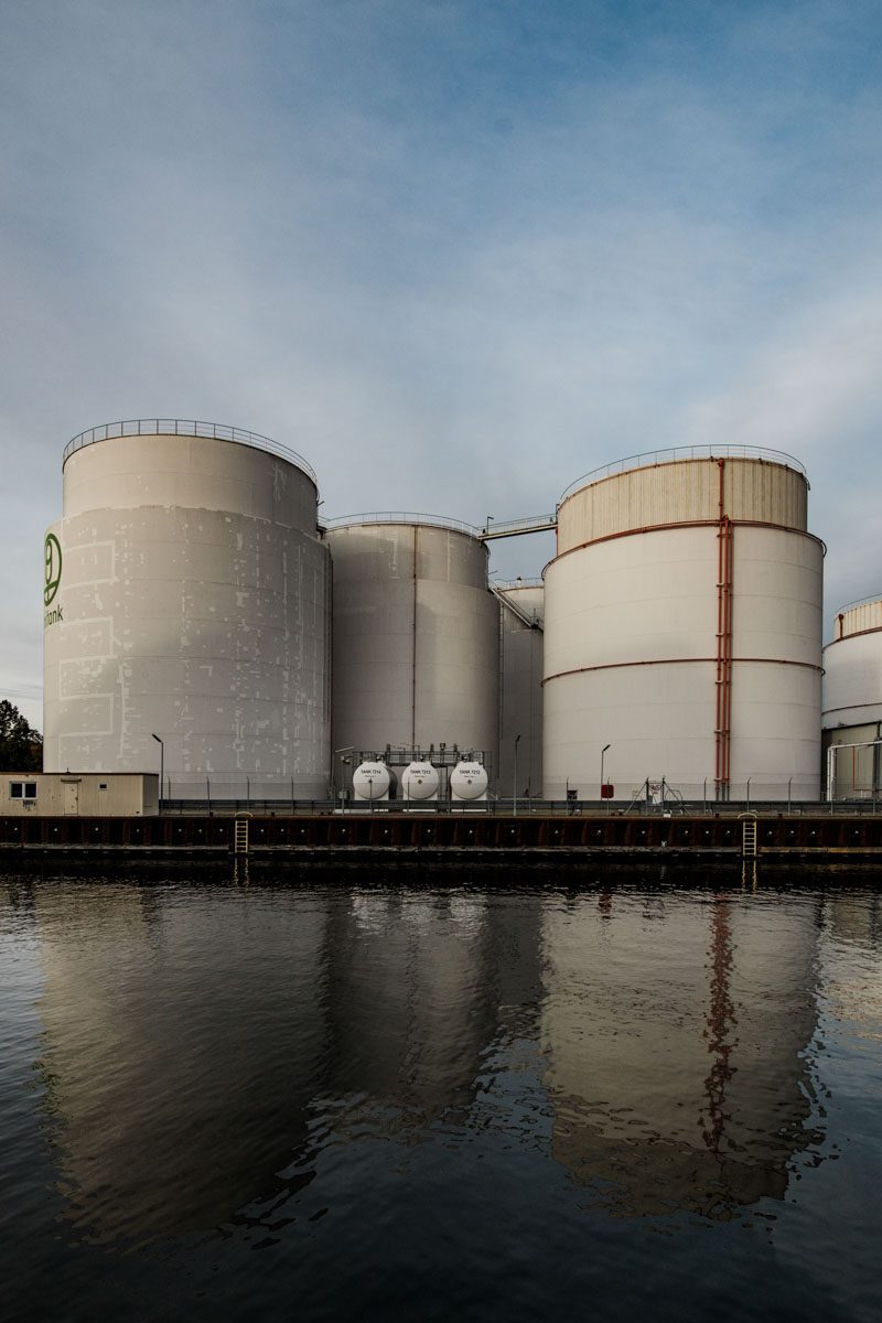 a large white tanks next to a body of water