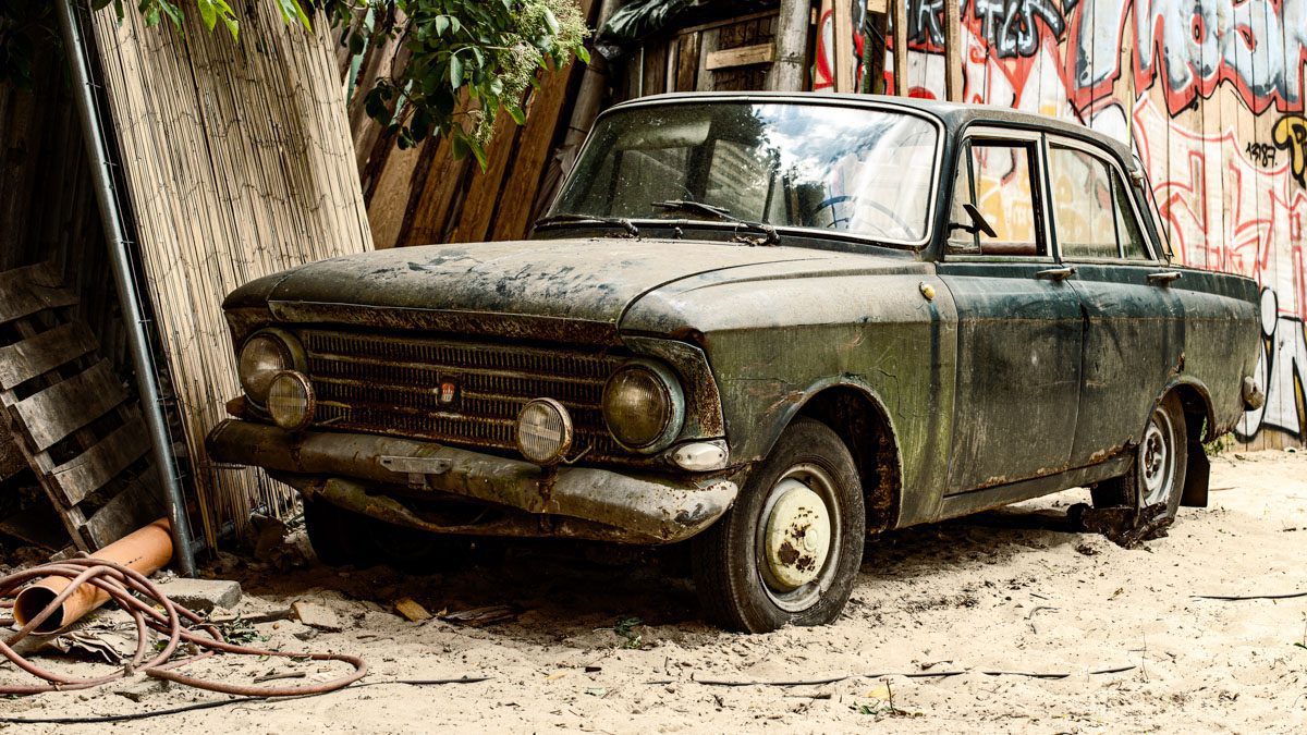 a old car parked in the dirt