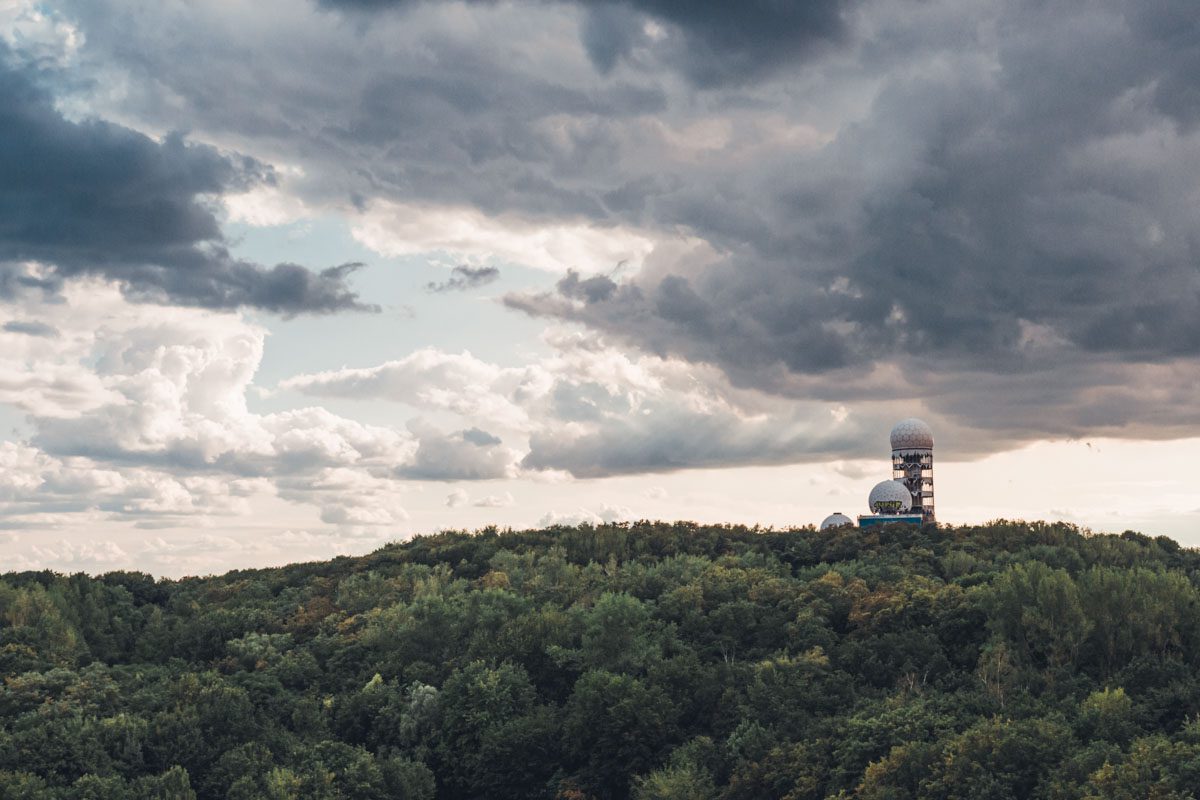 a building on a hill with trees in the background