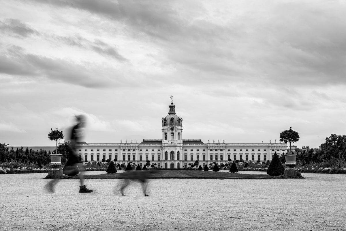 a large white building with a couple of people walking