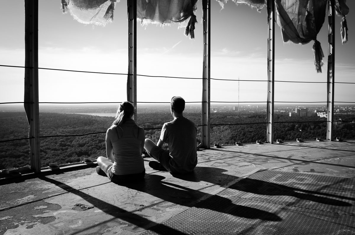 a person and person sitting on a balcony overlooking a valley